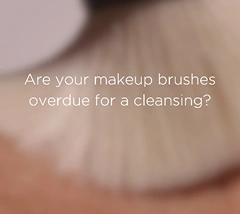 Text graphic asking 'Are your makeup brushes overdue for a cleansing?' against skin texture background