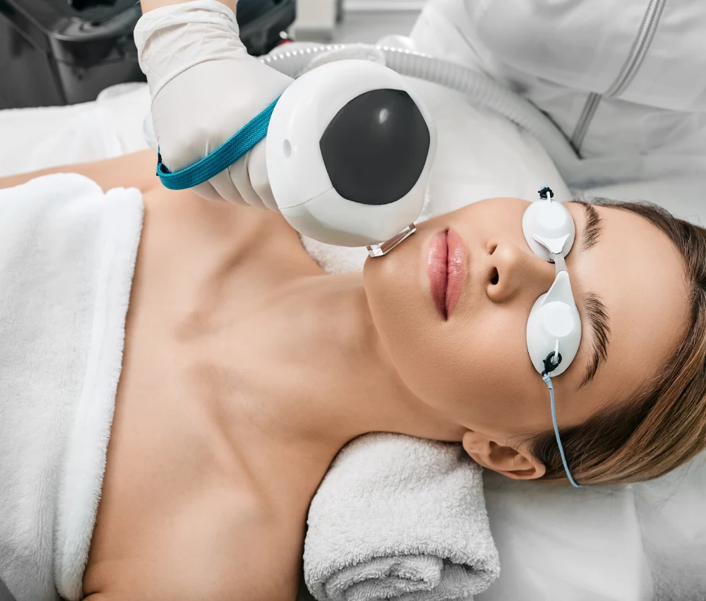 Practitioner applying Pico toning laser handpiece to client's face in Brea, CA.