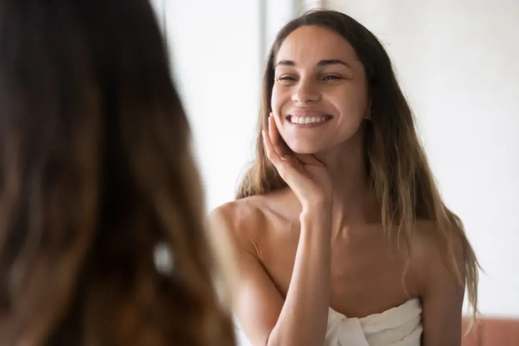 Smiling woman looking over her shoulder showcasing smooth skin texture