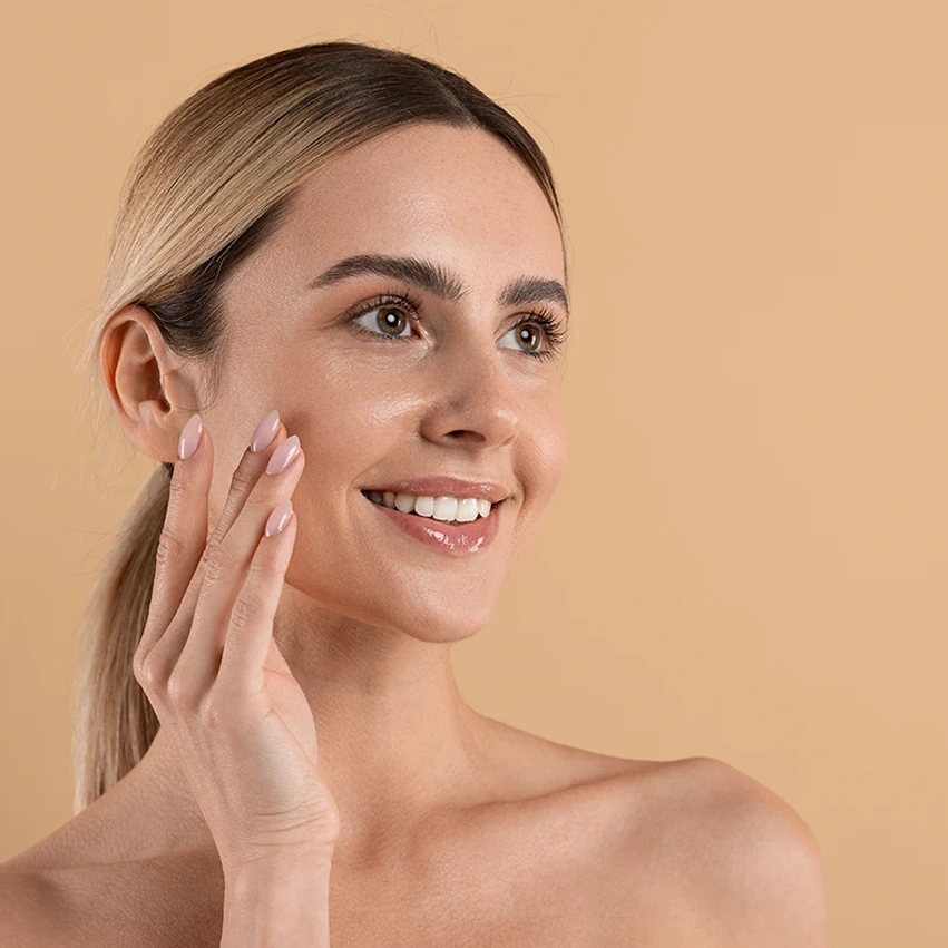 Woman gently touching her cheek to highlight smooth skin after dark spot removal treatment